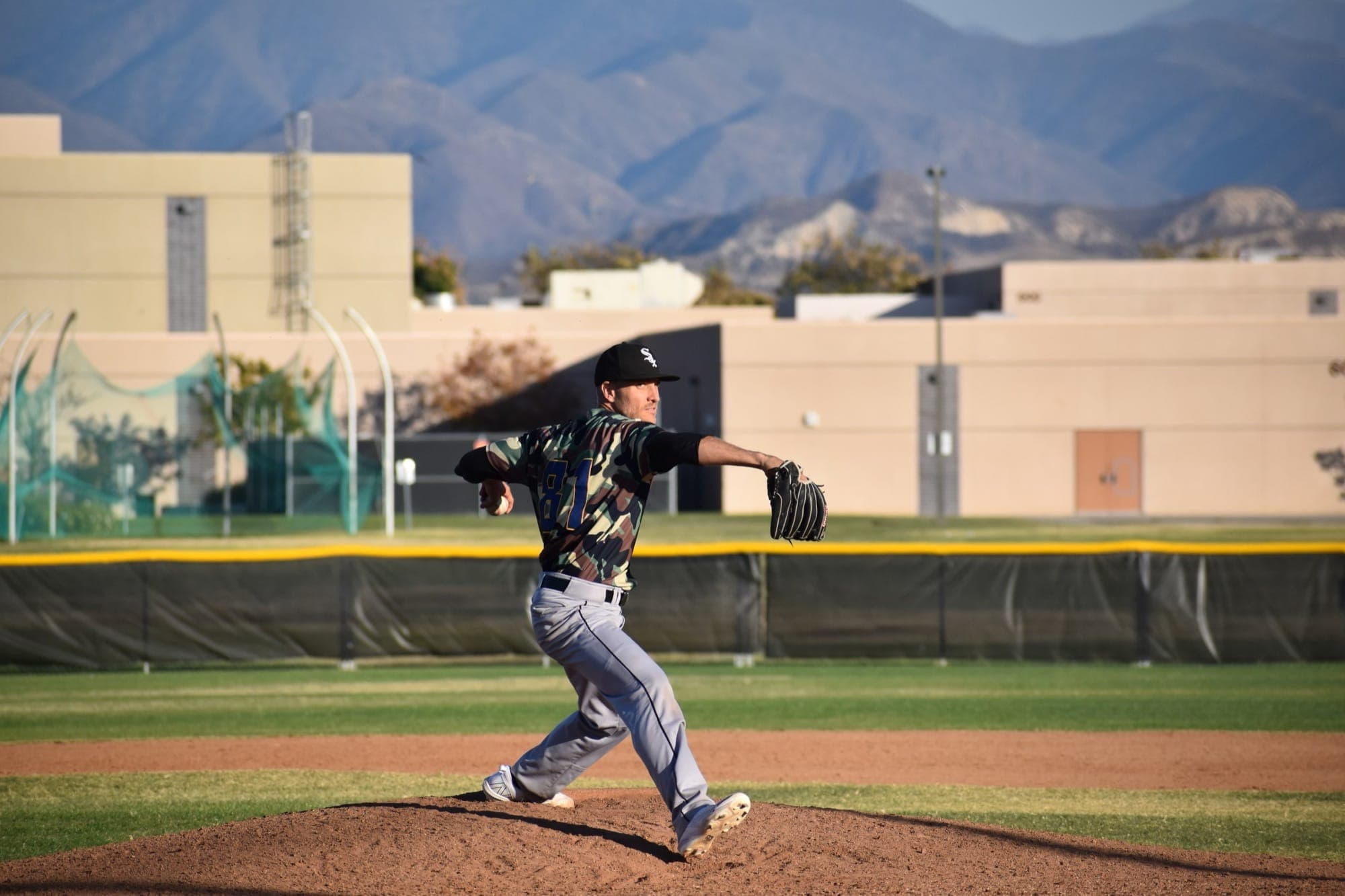 A pitcher in his delivery on a game mound